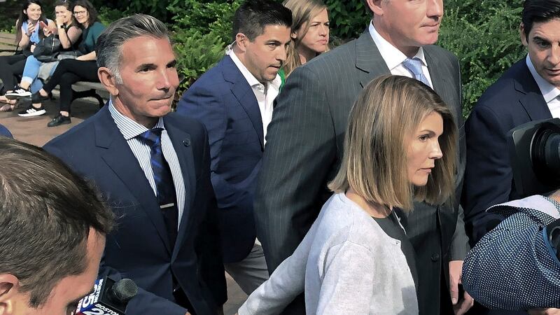 Lori Loughlin departs federal court in Boston with her husband, Mossimo Giannulli, left, after...