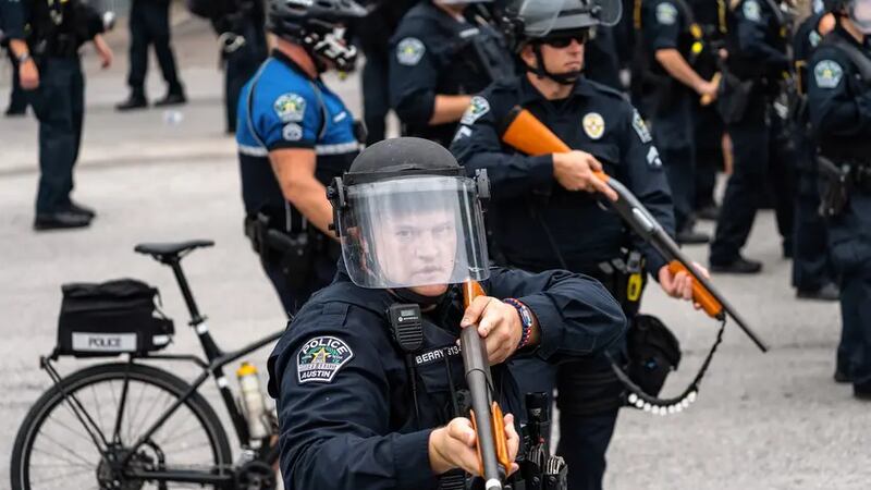 Austin police officer Justin Berry holds a weapon with so-called less-lethal rounds during a...