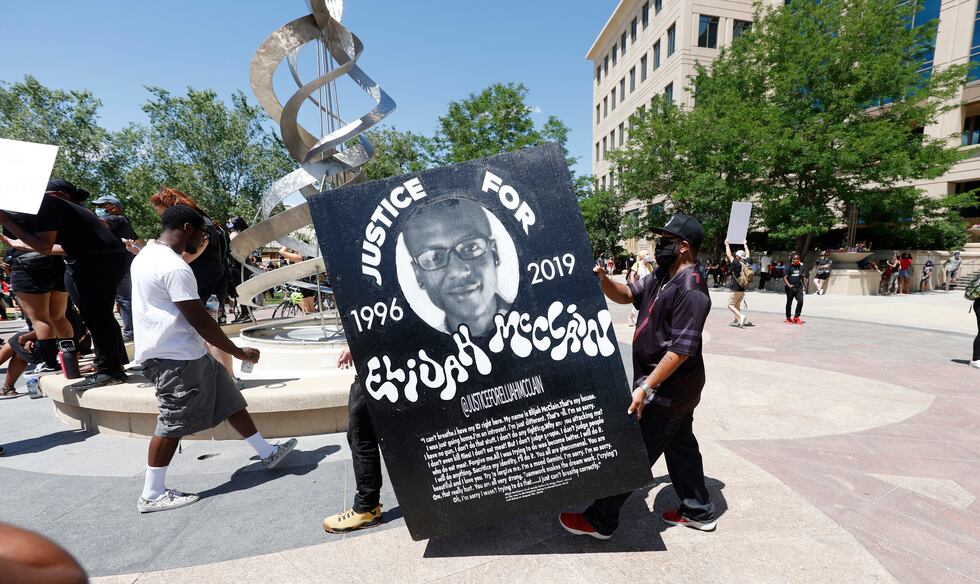 FILE - In this June 27, 2020, file photo, demonstrators carry a giant placard during a rally...