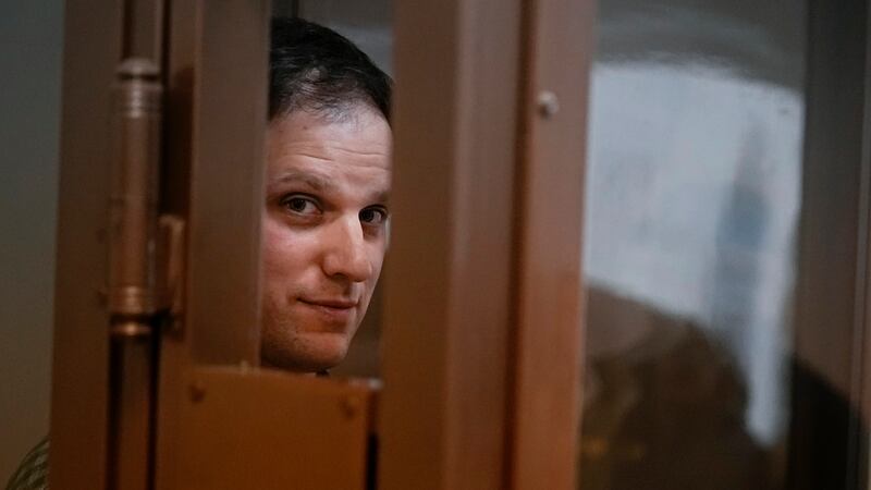 FILE - Wall Street Journal reporter Evan Gershkovich stands in a glass cage in a courtroom at...