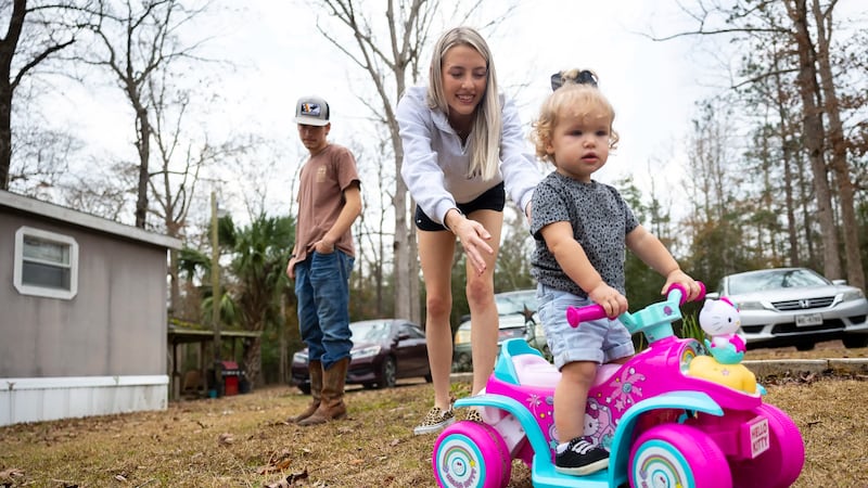 Chloe Walker and her 16-month old daughter, Everleigh, play outside their home in Newton on...